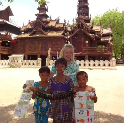 A woman and two children holding up paper