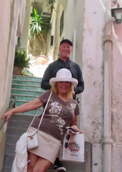 A man and woman standing on steps in front of a building.